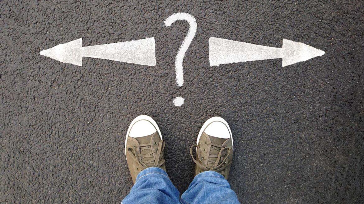 Feet in sneakers standing at question mark between arrows to left and right