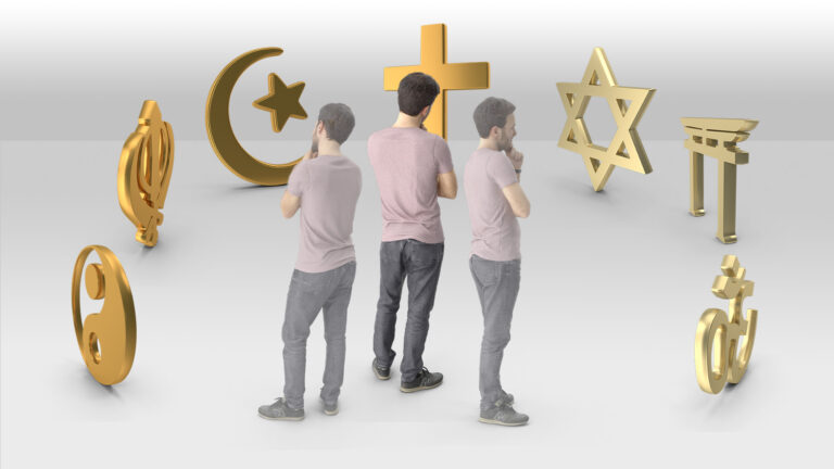 Three young adult men standing against a plain white background, with their backs to the viewer, looking at seven symbols of various religions in a semi-circle in front of them.