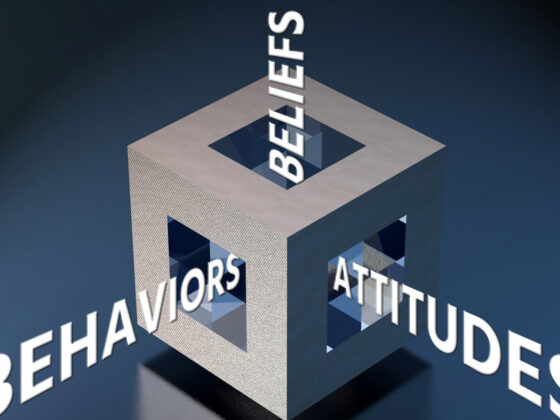 A hollow cube with the words beliefs, behaviors, and attitudes flowing out of each visible face.