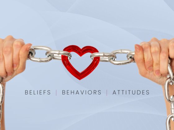 Hands holding a link-style chain, with the center link being a red heart. Text below reads beliefs, behaviors, attitudes.