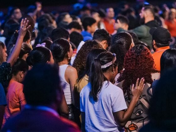 Students gathered in a worship service, with raised hands and bowed heads, illustrating the question of whether chapel participation becomes lasting worship after graduation.