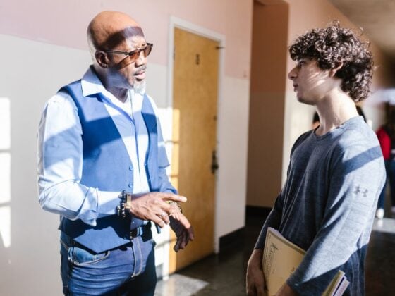 Adult mentor speaks with a student in a school hallway during a conversation about biblical worldview.